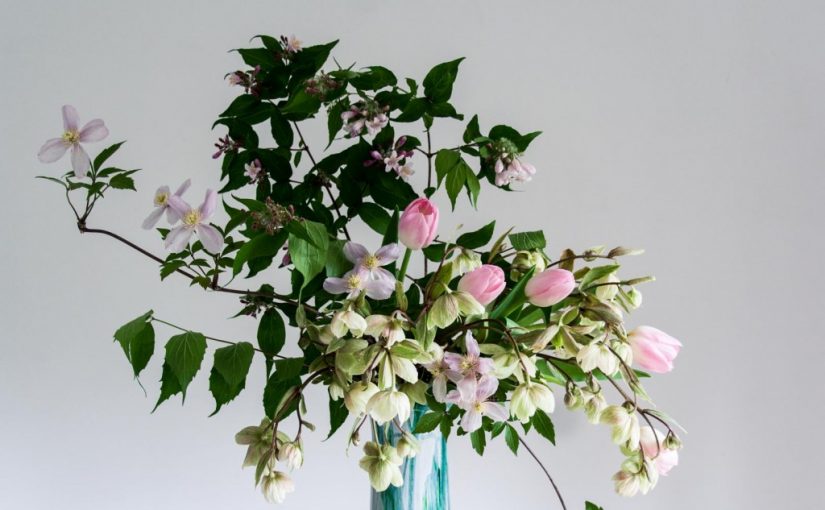 Spring floral arrangement featuring soft pink tulips, hellebores and clematis montana - Cloverhome.nl